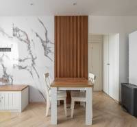 Dining area with a table and chairs, marble wall, wooden decor flooring in a 3-room apartment.