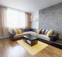 Living room in a 4-room apartment with a corner sofa and a floor with a wooden decor.