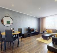 Living room in a 4-room apartment with a wooden decor floor and stylish furniture.