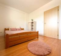 A bedroom with wooden furniture and a floor with a wooden decor in a 2-room apartment.