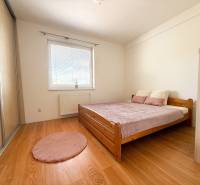 Bedroom in a 2-room apartment with a bed, wardrobe, and wooden decor flooring.