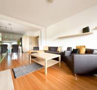 Living room in a two-room apartment with a sofa, table, and floor with a wooden decor.