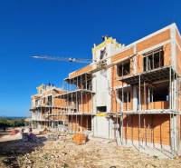 Construction of apartments in Petrčane, a building under construction with scaffolding and a crane is visible.