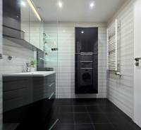 A modern bathroom in a 3-room apartment with cabinets, a sink, and tiles.