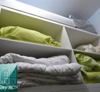 Storage space with bed linen in a 2-room apartment, shelves full of pillows and duvets.