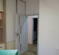 Interior of a 2-room apartment with a wooden decor floor and white doors.
