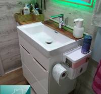 A bathroom in a 2-room apartment, bright with a sink and a mirror, tiles with a wooden decor.