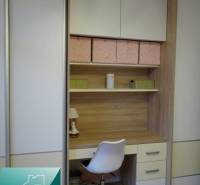A workspace with a white chair and a built-in wardrobe in a 2-room apartment.