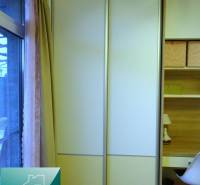 Sliding wardrobe and work corner with wood-decor flooring in a 2-room apartment.