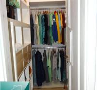 A wardrobe in a 2-room apartment with a wooden decor floor and organized storage space.