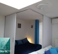 A one-room apartment with sliding doors, blue accessories, and decorative paintings on the wall.