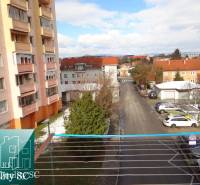 1st May Square Street in Senec with apartment buildings and a parking lot.