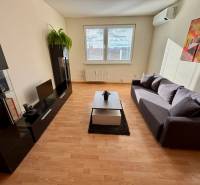 Living room in a 3-room apartment with a sofa, television, cabinet, and floor with wooden decor.