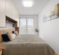 A bedroom in a 3-room apartment with a large bed, wardrobes, and a painting on the wall.