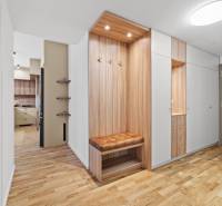 A hallway in a 3-room apartment with a wooden decor floor and built-in wardrobes.