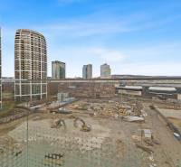 Construction site on Bottova Street in Bratislava, surrounded by high-rise buildings and shops.