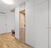 White built-in wardrobe with wood decor in a 3-room apartment, floor with wood decor.