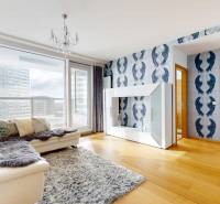 A stylish living space in a two-room apartment with a wood-patterned floor and a large window.