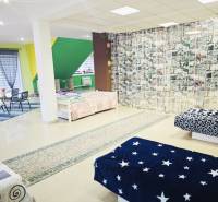 A spacious room in a family house with colorful elements and various bedspreads.