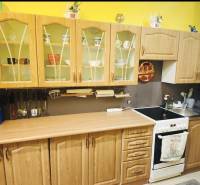 A kitchen in a family house with wooden cabinets and an electric stove.