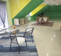 Interior of a family house with colorful walls, carpet, furniture, and dining table.