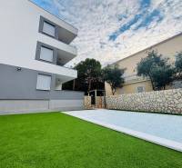 A holiday apartment in Novalja with a swimming pool and landscaped garden, modern architecture.