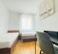 Bedroom in a holiday apartment with two beds and a wooden decor floor.