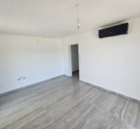 Room in a recreational apartment with air conditioning, light walls, and a floor with a wooden decor.