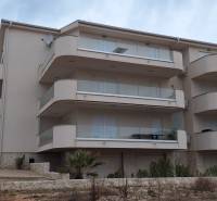 Exterior of a holiday apartment in Povljana with large balconies and minimalist design.