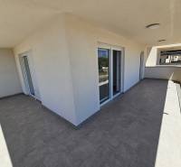 The large terrace at the holiday apartment in Povljana shines with a minimalist design and glass railings.