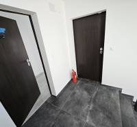 Interior of a holiday apartment with dark doors and flooring, fire extinguisher.