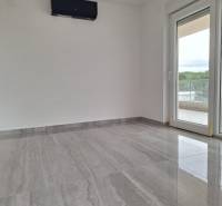 Recreational apartment with modern flooring, large window, and balcony.