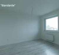 A room with a wooden floor decor, a window, and a radiator in a 2-room apartment.
