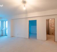 An empty 2-room apartment with white walls and an unfinished floor, waiting to be furnished.
