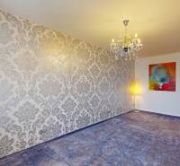 A room in a 3-room apartment with wallpaper, a chandelier, and a floor lamp.