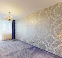 Living room in a 3-room apartment with a wallpapered wall and a chandelier.