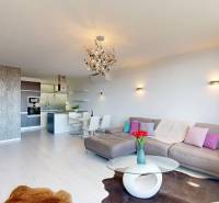 Living room in a 3-room apartment with a wooden decor floor, light walls, and a sofa.