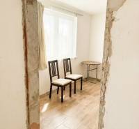 Interior of a family house with two chairs and a wooden-patterned floor.