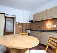 A kitchen in a 3-room apartment with wooden furniture and a floor with a wooden decor.