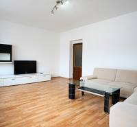 Living room in a 3-room apartment with a corner sofa, TV, and floor with a wooden decor.