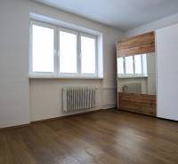 A room with a wooden floor design and a large wardrobe in a 3-room apartment.