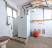 Technical room with a boiler and piping system in a family house.