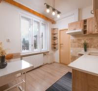 A family house kitchen with a wooden decor floor and light furniture.