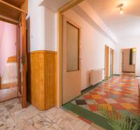 A hallway in a family house with a tiled floor and wooden accessories.