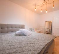 Bedroom in a 3-room apartment with a large bed and a wooden decor floor.