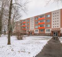 A four-story apartment building with a snow-covered lawn on Bezručova Street in Trenčín.