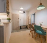 Kitchen and dining area in a 3-room apartment with a wooden decor floor.