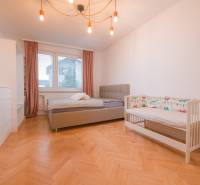 Children's room in a 3-room apartment with a wooden decor floor, a bed, and a crib.