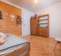 A room in a 3-room apartment with a wood-patterned floor and a decorative wooden wall.