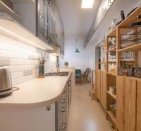 Cozy kitchen with wooden shelves and white tiles in a 3-room apartment.